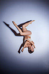 Image showing Young beautiful dancer in beige swimwear dancing on lilac background