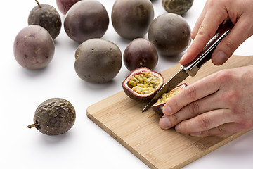 Image showing Knife Cutting A Passion Fruit Into Halves