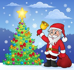 Image showing Santa Claus with bell by Christmas tree