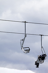 Image showing Snowboarders in chair lift at gray windy day