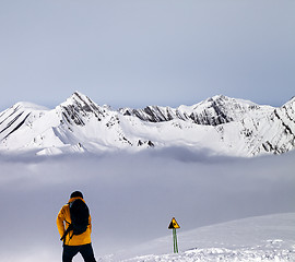 Image showing Freerider on off-piste slope in mist and warning sing