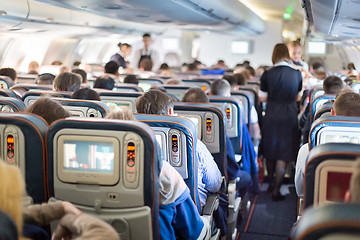 Image showing Interior of airplane with passengers on seats.