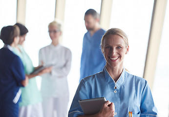 Image showing female doctor with tablet computer  standing in front of team