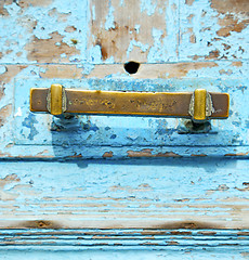 Image showing rusty metal     nail dirty stripped paint in the blue wood door 