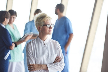 Image showing female doctor with glasses and blonde hairstyle standing in fron