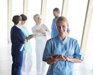 Image showing female doctor with tablet computer  standing in front of team