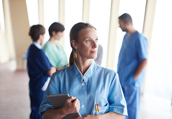 Image showing female doctor with tablet computer  standing in front of team