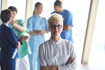 Image showing female doctor with glasses and blonde hairstyle standing in fron