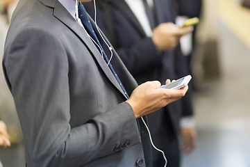 Image showing Businessmen using their cell phones on subway.