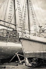 Image showing Old collapsing sailboats at the dock, close-up, sepia