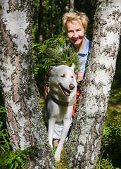 Image showing Portrait of a woman with a dog on a walk in the woods