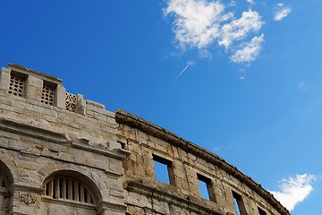 Image showing Contrail of the jet plane above ancient Roman amphitheater in Pula, Croatia