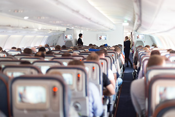 Image showing Interior of airplane with passengers on seats.