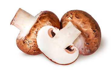 Image showing Two whole and half brown champignons