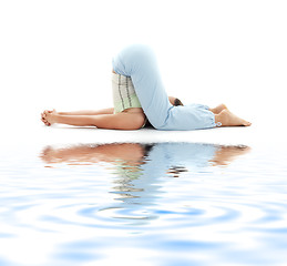 Image showing halasana plow pose on white sand