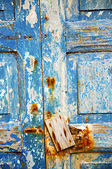 Image showing dirty stripped paint in the  door and   nail