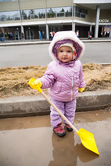 Image showing Young girl stands in pool with shovel