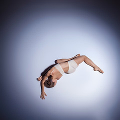 Image showing Young beautiful dancer in beige swimwear dancing on lilac background