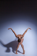 Image showing Young beautiful dancer in beige swimwear dancing on lilac background