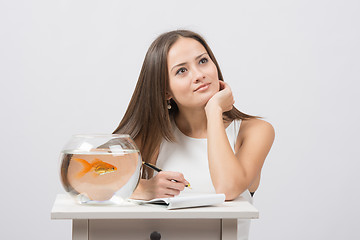 Image showing She thought about writing in a notebook desire to fulfill a goldfish