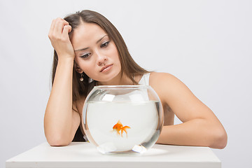 Image showing Upset young girl looking at goldfish in a fishbowl