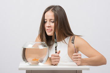 Image showing She licked and wants to eat the little goldfish
