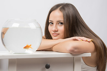 Image showing She thought watching the little goldfish in an aquarium