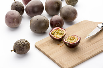 Image showing Freshly halved Passion Fruit On A Bamboo Board