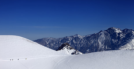 Image showing Snowboarders move on footpath to off piste slope at sun day