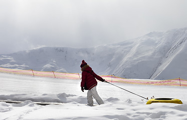 Image showing Girl with snow tube at sun day