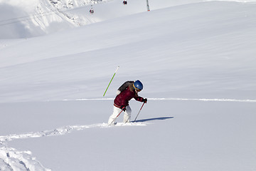 Image showing Little skier on off-piste slope with new fallen snow at sun day