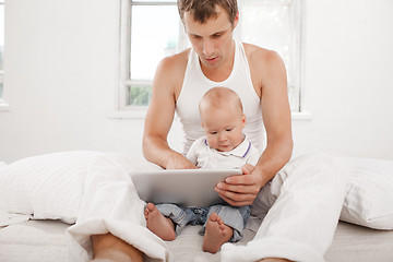 Image showing Young father and his nine months old son with digital tablet