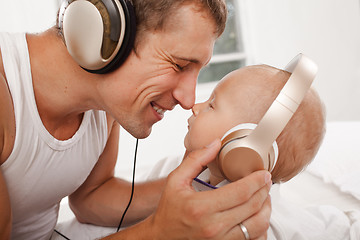 Image showing young father with his nine months old som on the bed at home