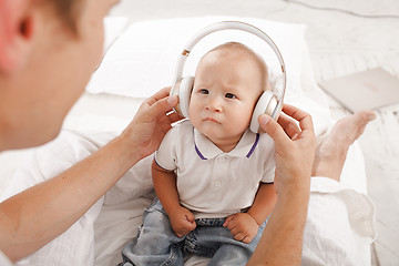 Image showing young father with his nine months old som on the bed at home