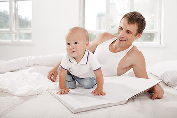 Image showing Father and baby together reading book
