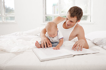 Image showing Father and baby together reading book