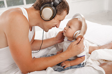 Image showing young father with his nine months old som on the bed at home