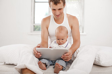 Image showing Young father and his nine months old son with digital tablet