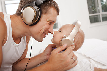 Image showing young father with his nine months old som on the bed at home