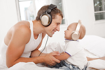 Image showing young father with his nine months old som on the bed at home