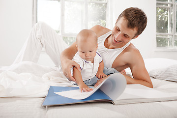 Image showing Father and baby together reading book