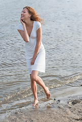 Image showing Pretty woman in a white dress on coast