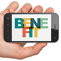 Image showing Finance concept: Hand Holding Smartphone with Benefit on  display