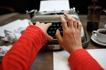 Image showing woman typing on old typewriter