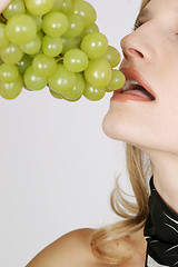 Image showing Young woman eating grapes