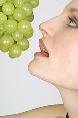 Image showing Young woman eating grapes