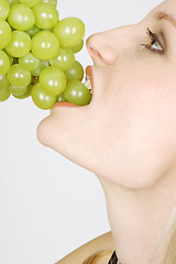 Image showing Young woman eating grapes