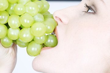 Image showing Young woman eating grapes