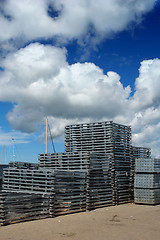 Image showing Stacked pallet boards in port