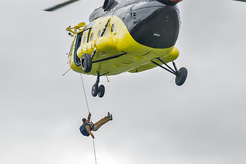 Image showing Rescuer is landed from MI-8 helicopter by rope